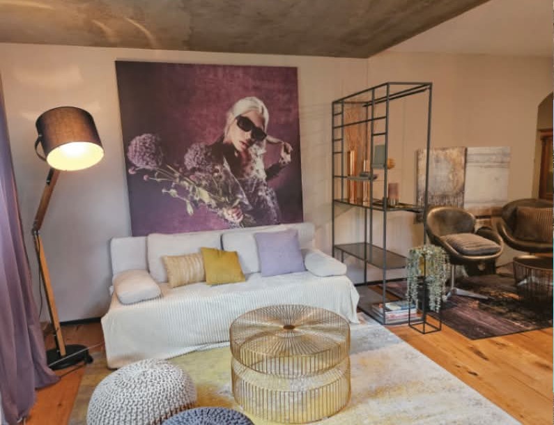 Künstlerwohnung in Langenargen am Bodensee, Lounge mit Großformat-Fotoarbeit, Atelierregal und Messingtisch